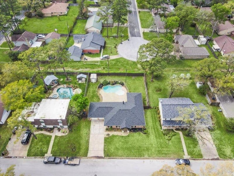 Residential aerial photograph showing the home, lot, driveway, and surrounding neighborhood.