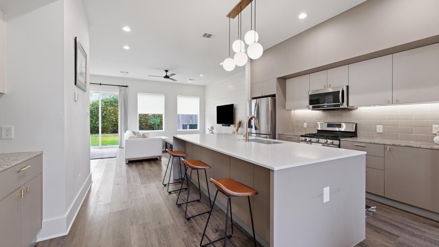 Open kitchen with island and adjacent living area photographed for the Houston listing.