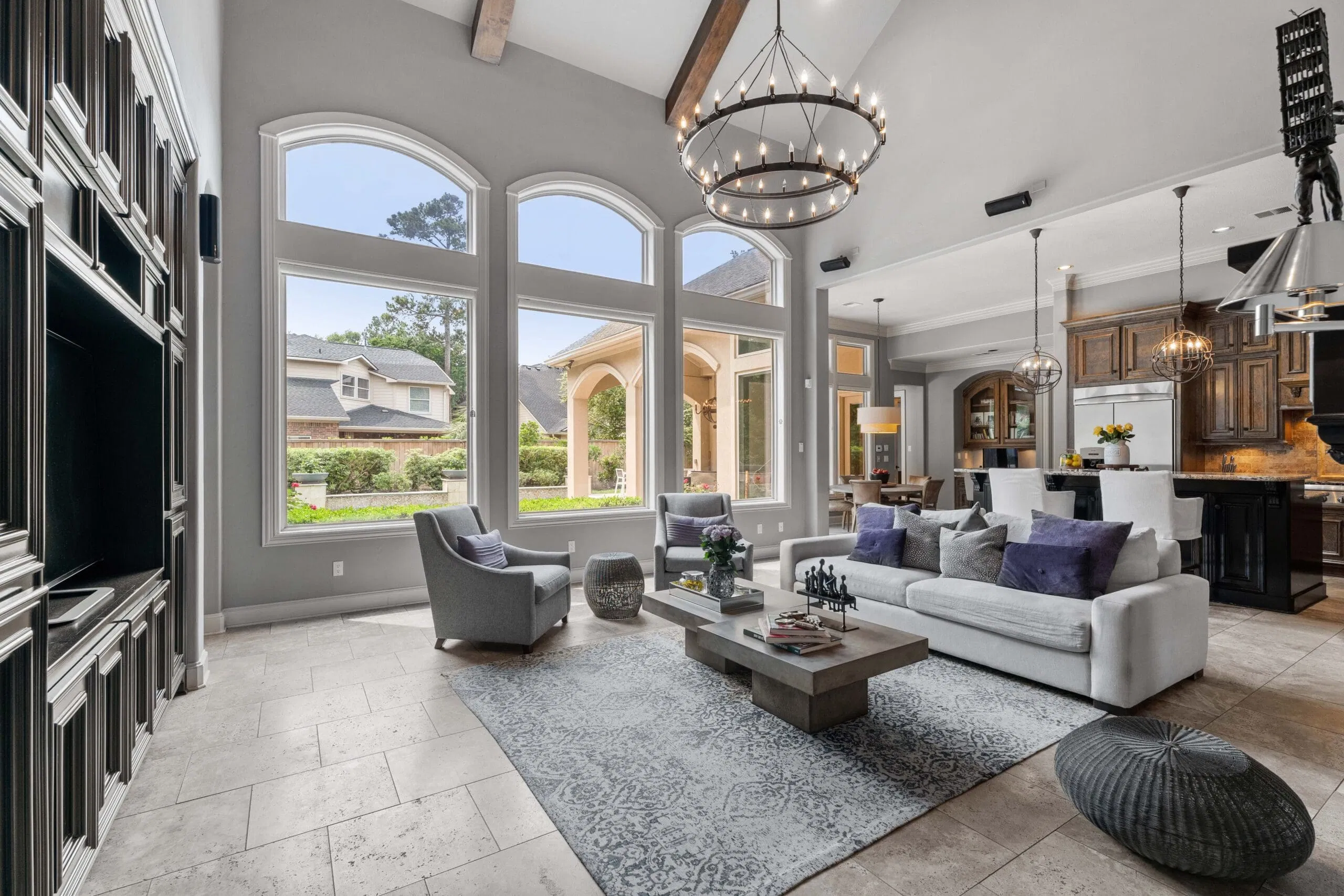A bright, grand living room with soaring ceilings and floor-to-ceiling windows in a luxury Cypress home.